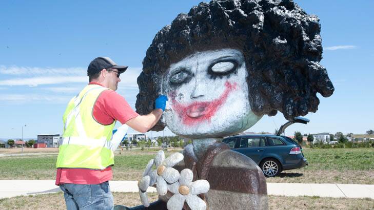 Doug Rogan of International Conservation Services cleans graffiti off of the "Lady with Flowers" sculpture on Flemington Road, Gungahlin. Photo: Daniel Spellman