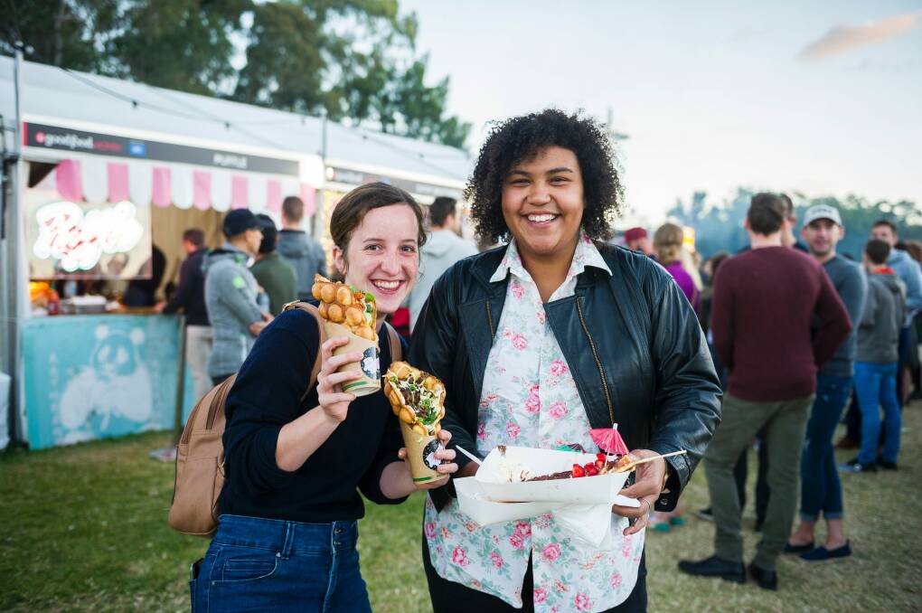 Caroline Delaisse and Alicia Wingyip enjoy some of the different foods the night markets has to offer. Photo: Dion Georgopoulos