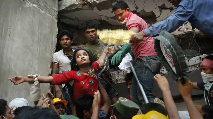 Alive: A survivor is lifted out of the rubble by rescuers on Thursday. Photo: AP