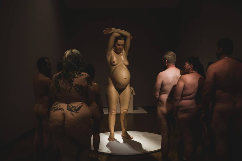 Art buffs take in Ron Mueck's 'Pregnant woman' at the National Gallery of Australia during a naked event at Hyper Real. Photo: Jamila Toderas