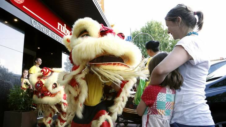 Cleo Sexton and Helen Sexton from Dickson watch members of the Prosperous Mountain Lion Dance Troupe perform in Woolley Street in Dickson. Photo: Jeffrey Chan