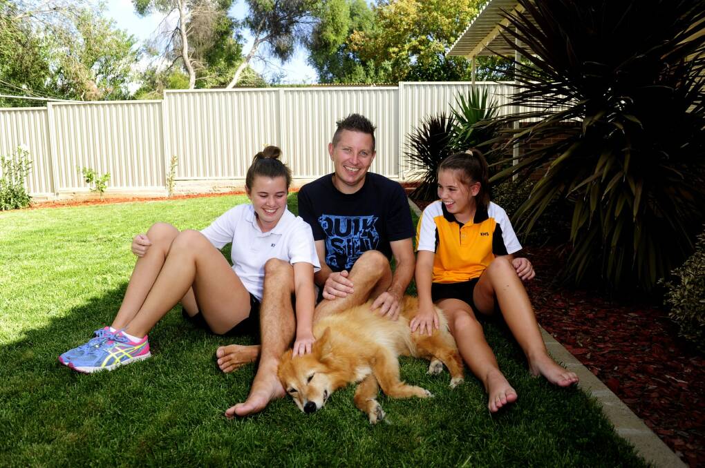 Andrew McInnes with daughters Courtney,15 (left), and Taya,13, and their dog Gypsy, at home in Queanbeyan.  Photo: Melissa Adams
