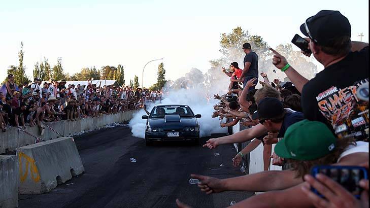 Smoke on the bitumen: Fans show their appreciation as a driver does a burnout in Canberra. Photo: Alex Ellinghausen