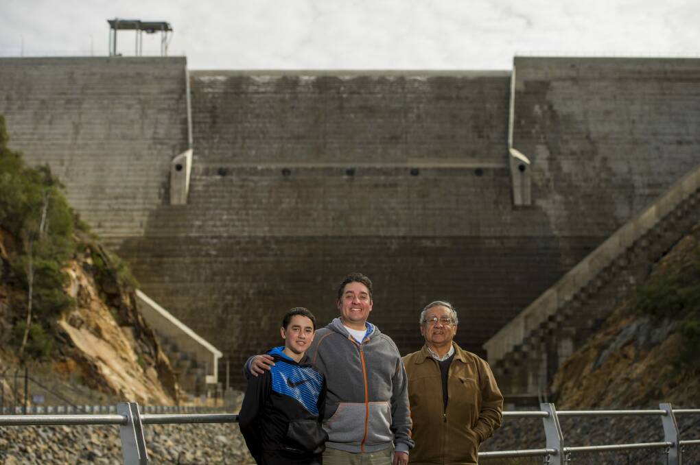 Three generations of the Hansen family Joe, 12, Richard and David watch the first spill of the Cotter Dam. Photo: Jay Cronan