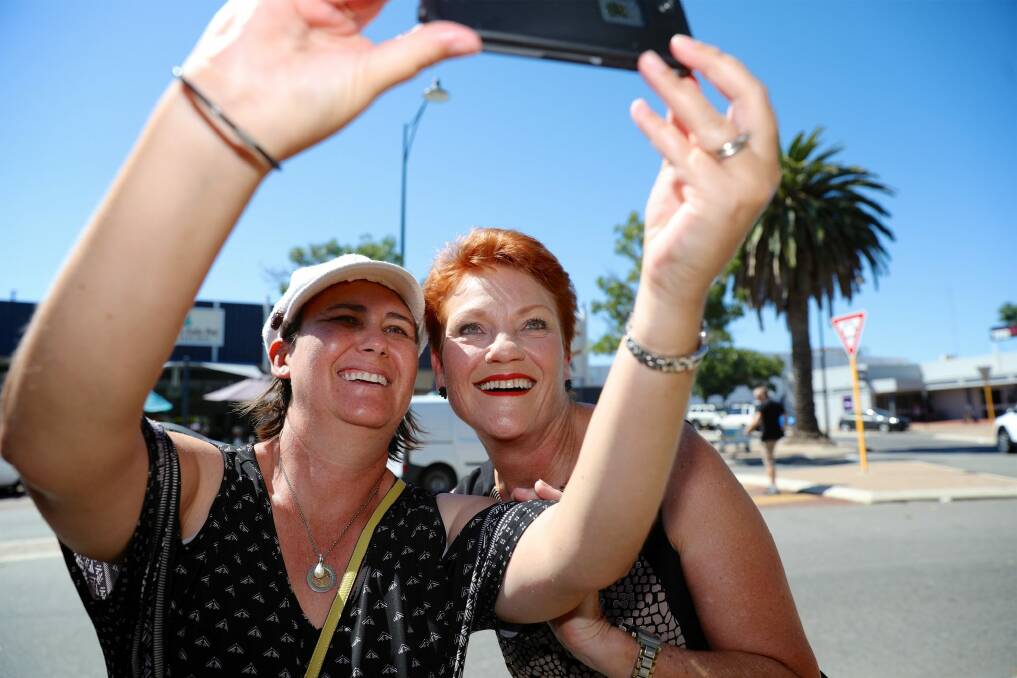 One Nation leader Pauline Hanson has a picture taken with a member of the public while campaigning in Mandurah, south of Perth. Photo: Richard Wainwright