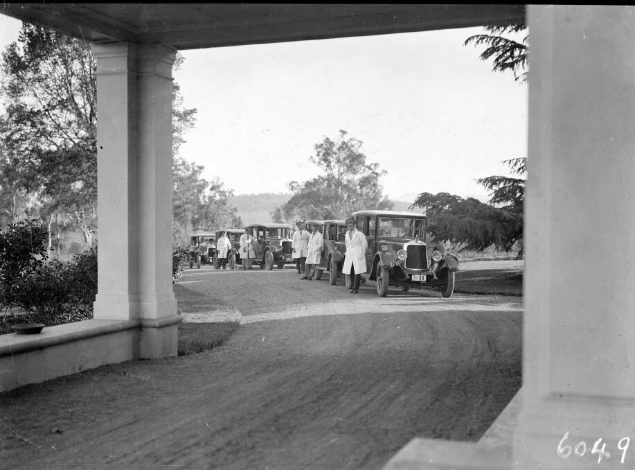 White-coated Commonwealth drivers and their Armstrong Siddeley cars gather at the Governor-General's residence in Yarralumla, circa 1930. Photo: the Mildenhall Collection