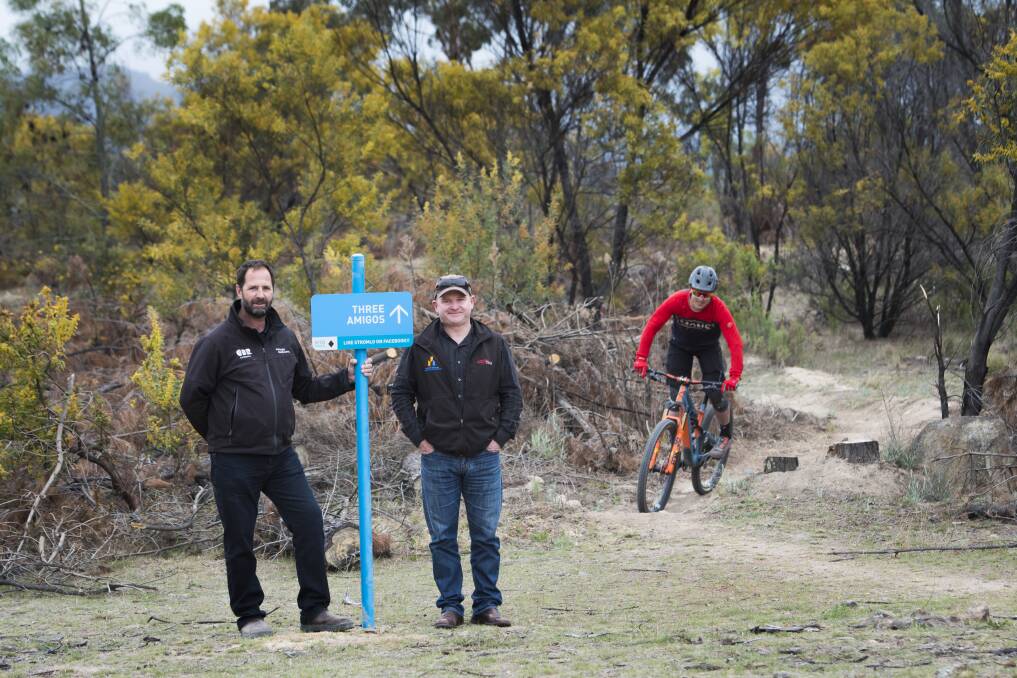Stromlo Forest Park manager Jeff van Aalst, Canberra Off-Road Cyclists vice president Darren Stewart with mountain biker and volunteer trail builder Ryan Walsch at Three Amigos, a new trail. Photo: Elesa Kurtz
