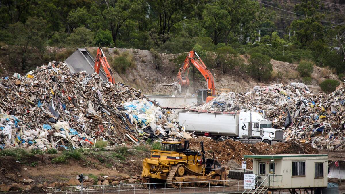 Hive of activity: At BMI Group's Swanbank recycling facility, the grey truck seen tipping on the left, which carries NSW plates, adds to a pile of unprocessed waste being loaded on to local trucks. Photo: Mark Solomons