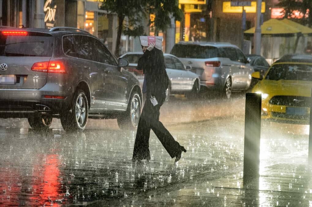 Pedestrians battle torrential rain in Civic on Thursday afternoon.  Photo: Sitthixay Ditthavong