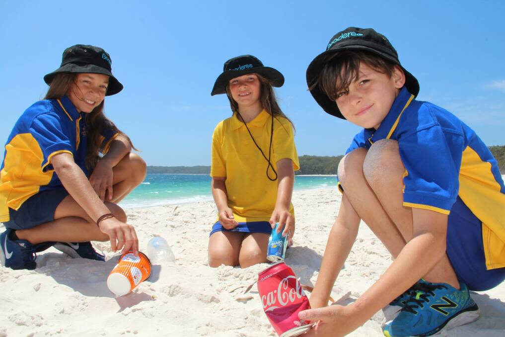 Jervis Bay Primary School students Priscilla Dann, 11, Ocean Wellington, 8, and Elih Ardler-Pascoe, 10, helping clean up the beach to Keep Booderee Beautiful. Photo: Parks Australia