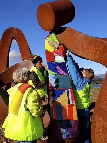 The knitting display being installed on trees and sculptures at National Arboretum Canberra. Photo: Supplied