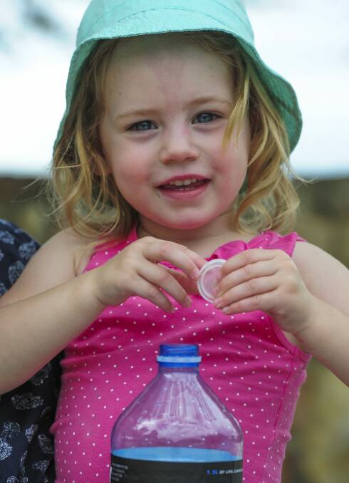 Eleanor Anderson, 2, of Kambah, shows how recycling should be done. The ACT government has launched a new campaign encouraging Canberrans to remove lids from containers before putting them in the recycling bin.  Photo: Graham Tidy