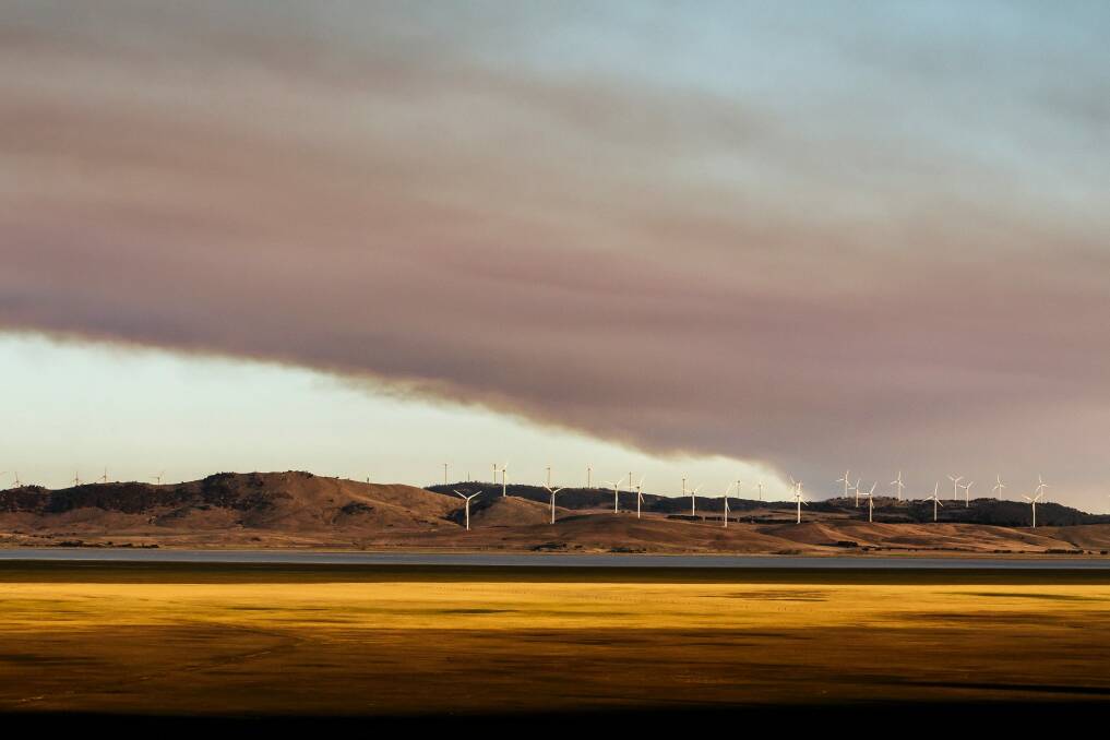 A large plume of smoke from the Braidwood fire seen over Capital Wind Farm near Bungendore on Friday evening. Photo: Sitthixay Ditthavong