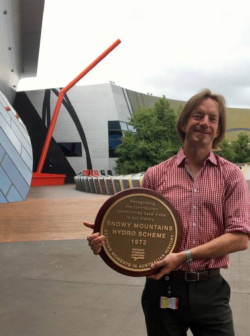National Museum of Australia curator, Jonathan Lineen, who curated the "Defining Moments'' history project,  with the plaque that will be presented to the town of Cooma on Sunday. Photo: Supplied