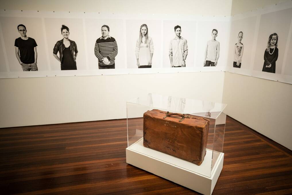 A suitcase and a series of portraits by Linda Wachtel feature in The Gift, an exhibition about migration at the Museum of Australian Democracy at Old Parliament House. Photo: Mark Nolan