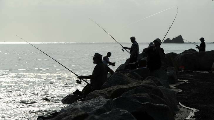 Fishermen on the breakwater at Corrigans Beach, Bateman's Bay on Saturday. Photo: Graham Tidy
