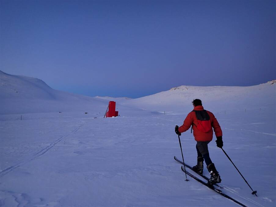 Charlie Freer cross country skis towards Cootapatamba Hut in the gloaming just after sunset.  Photo: Peter Blunt