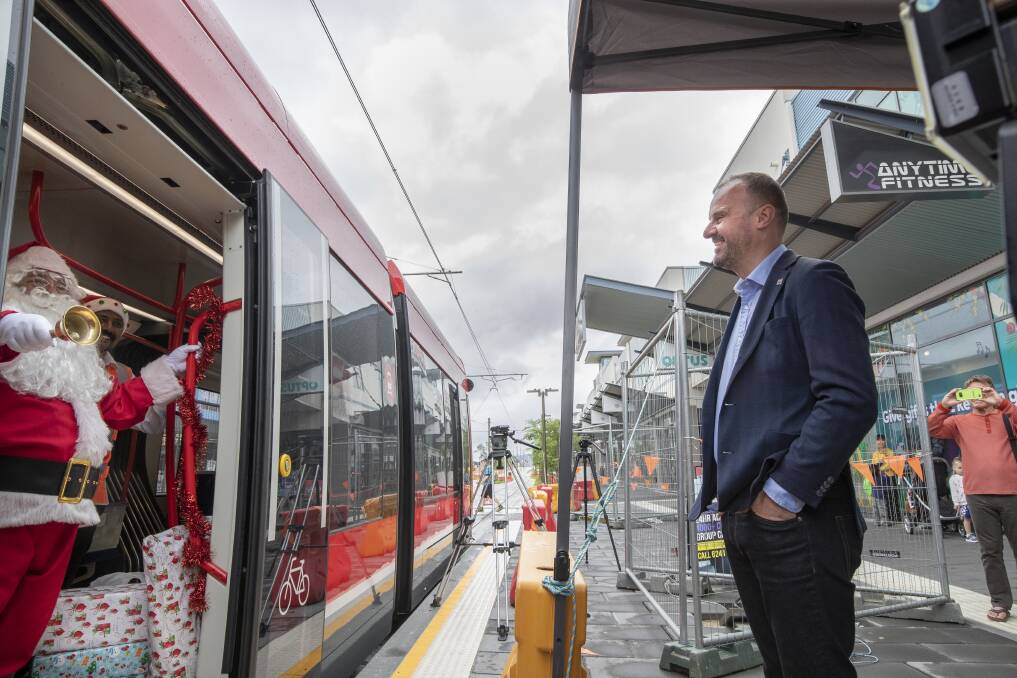 ACT Chief Minister Andrew Barr greets Santa after he arrived at the Gungahlin light rail terminal with gifts for the St Vincent de Paul Society. Photo: Sitthixay Ditthavong