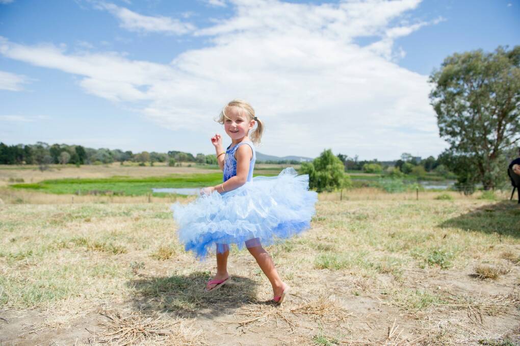 Violet Pipe, 3, enjoying a twirl at the Jerrabomberra Wetlands Open Day. Photo: Jay Cronan