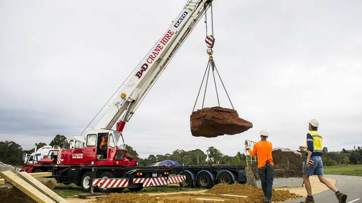 One of the new 11-tonne banded iron formation rocks is lifted into the National Rock Garden. Photo: Rohan Thomson