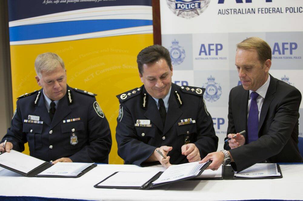 ACT Chief Police Officer Rudi Lammers, left, AFP Commissioner Tony Negus, and Police Minister Simon Corbell sign the policing agreement.  Photo: Jamila Toderas
