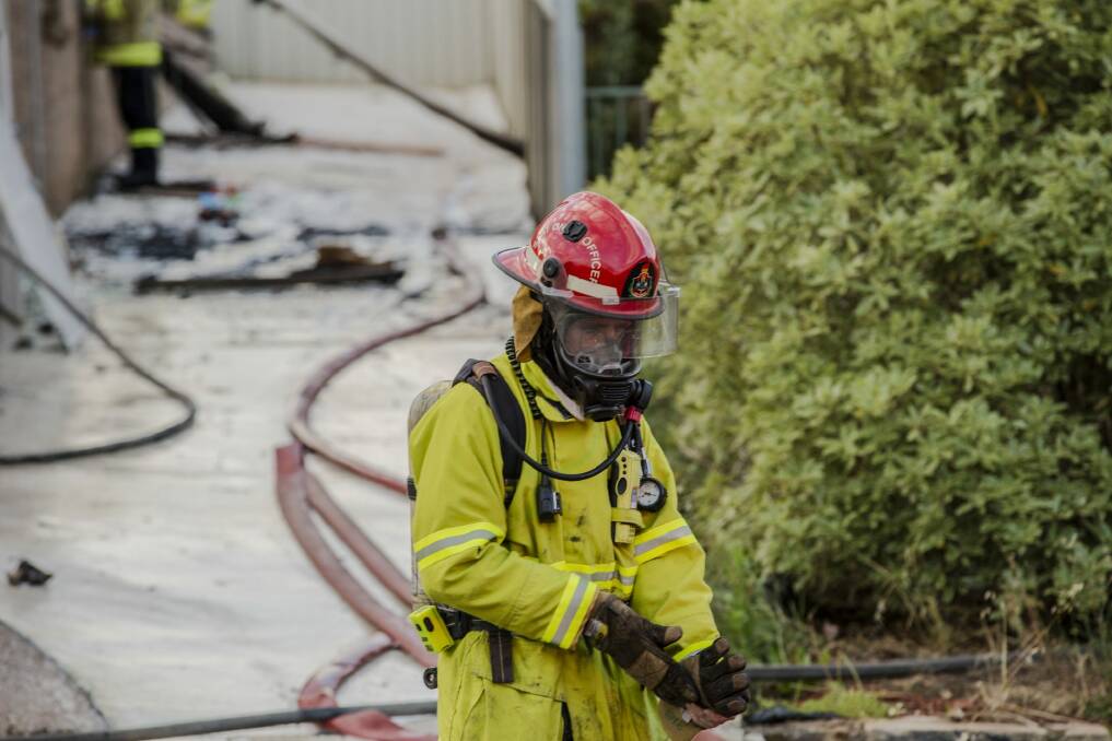 A firefighter on the scene of a house fire at Kinsella Street at Karabar on Friday. Photo: Jamila Toderas.