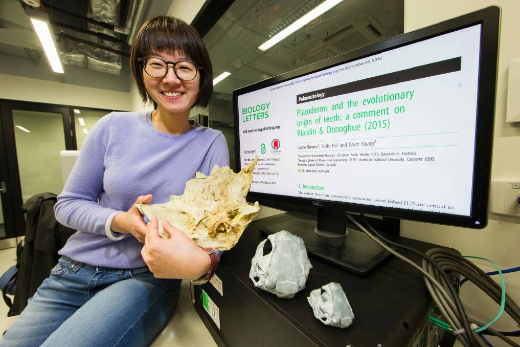 ANU PhD student Yuzhi Hu with a 3D model of a fish fossil created after completing a CT scan on the fossil found near Lake Burrinjuck Photo: Stuart Hay