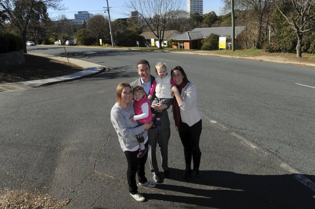  Four adjoining homes in Burnie Street, Lyons, belonging to
members of the Barclay family, will be auctioned together on July 2.
From left, Michelle holding two-year-old twin Ellie, her husband Steven,
holding Asher and Alison, Steven's sister.  Photo: Graham Tidy