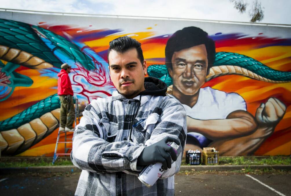 David 'Dsee' Chavez and with the mural of Jackie Chan on Challis Street in Dickson.  Photo: Elesa Kurtz