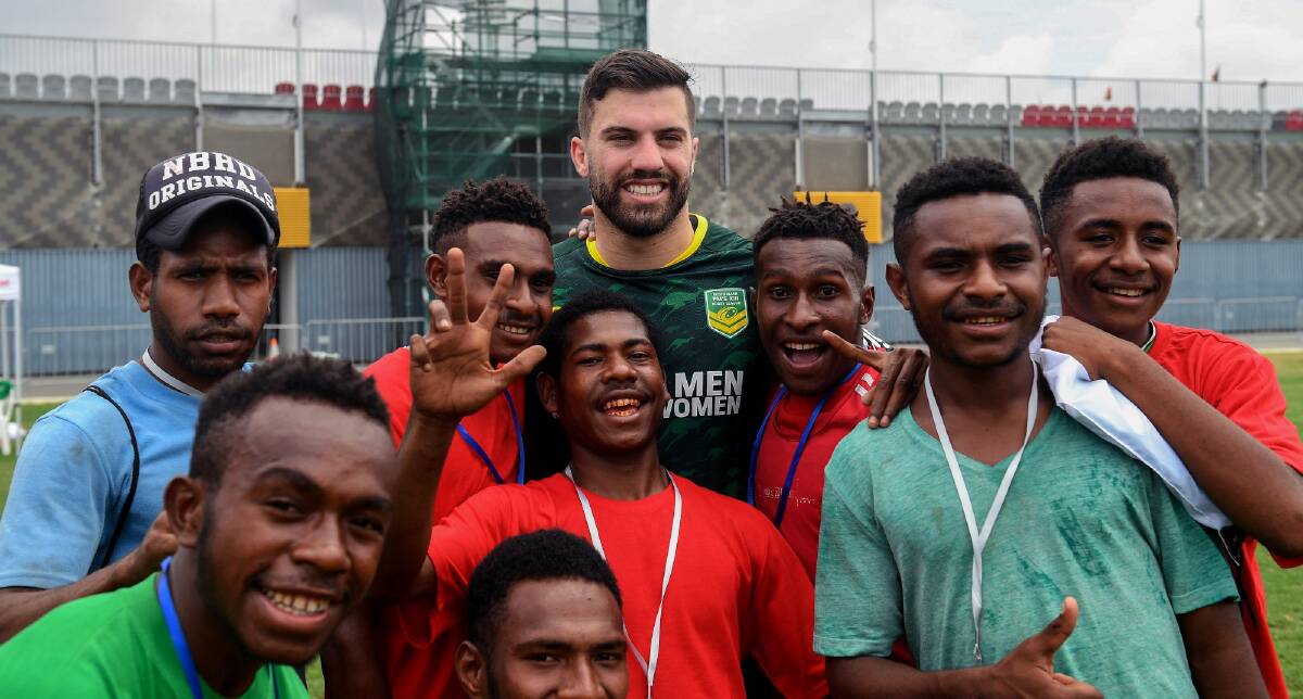 Making friends: James Tedesco at a coaching clinic in Port Moresby. Photo: AAP