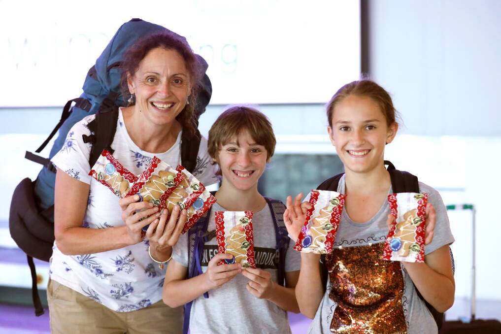 Passengers at Canberra Airport, including this family from Wagga, were delighted to find some gingerbread on the baggage carousel as a Christmas surprise this week. Photo: Ellen Britton