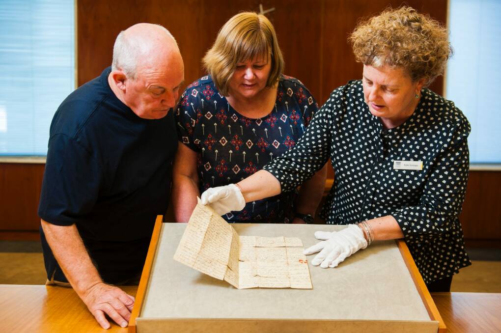 A letter written by William Charleson from Van Diemen's Land on 25 March, 1824, to his mother in Caithness, Scotland donated to the National Library of Australia.
Left to right: researcher Keith Blackburn, family donor of letter Claire Henson and (in gloves) curator Kylie Scroope. Photo: Elesa Kurtz