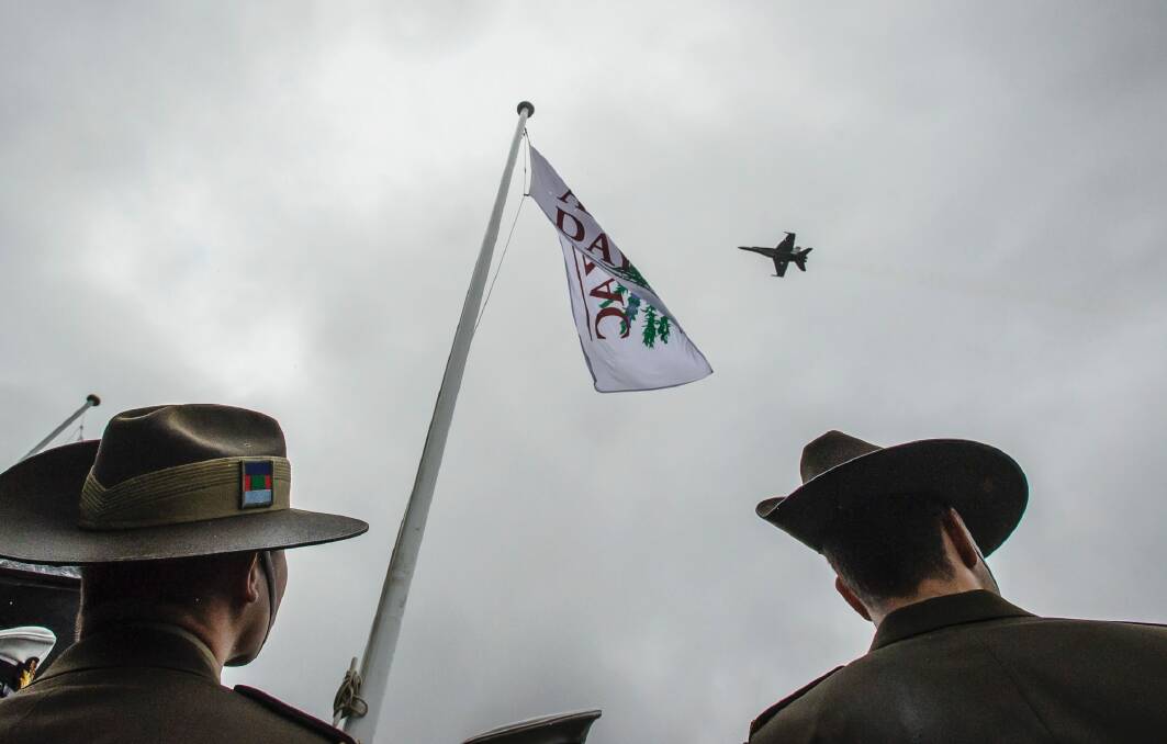 An F-18 Hornet flies over ADFA trainee officers at the conclusion of the 2017 Anzac Day National Ceremony. Photo: Sitthixay Ditthavong