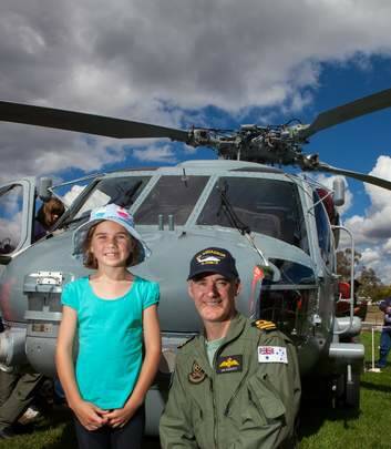 Alicia Regan age 7 of Flynn stands in the front of a Seahawk helicopter with co-pilot Ian Parrott. Photo: Katherine Griffiths