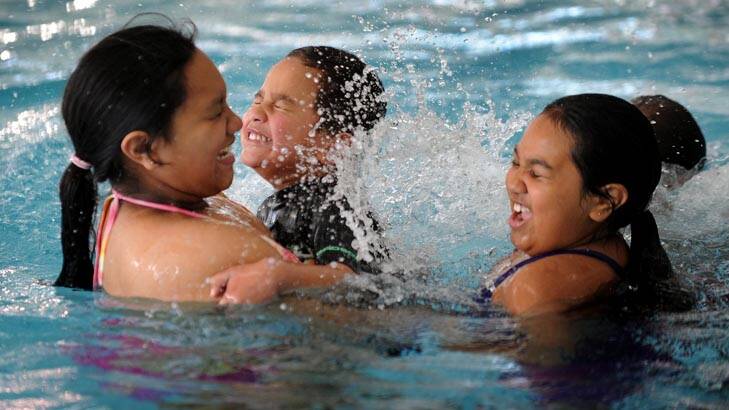 Swim programs ... Tahlia Jard, 10, holds her brother Roderick as sister Alyssa plays in the pool. Photo: Colleen Petch