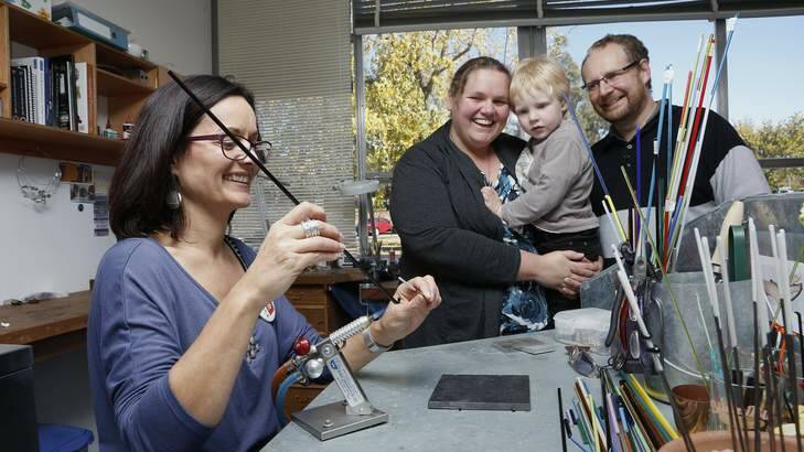 Silversmith, Glass Artist Sarah Murphy shows Kate Moerman with Alec Barrow 3-1/2 and Stuart Barrow from MacGregor how to flame work glass beads during the Centenary Street Party at the M16 Artspace. Photo: Jeffrey Chan