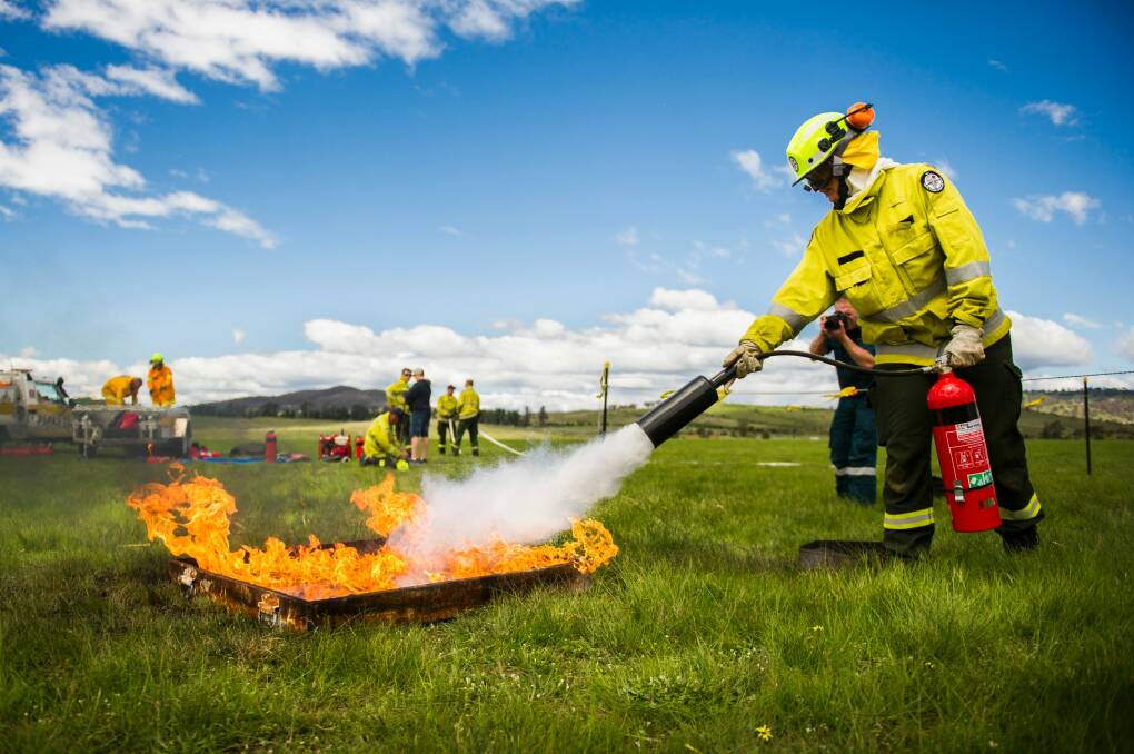 Before... a firefighter demonstrates putting out a small fire using a fire extinguisher. Photo: Rohan Thomson