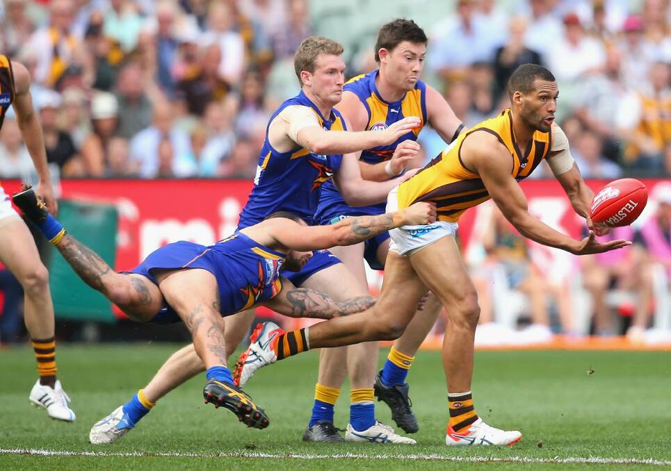 Josh Gibson handballs as he is tackled by Chris Masten of the Eagles. Photo: Getty Images