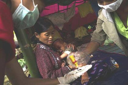 A mother and child receive medical aid in a jungle in the far north of Burma, where soldiers have been fighting rebels since a 17-year ceasefire ended in June.