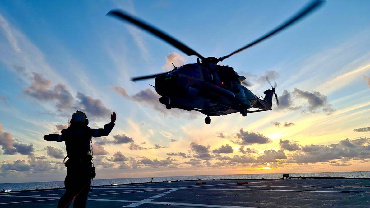 An MRH-90 helicopter from 808 Squadron is marshaled in to land on HMAS Supply during first-of-class flight trials off the coast of Queensland. Picture: Department of Defence
