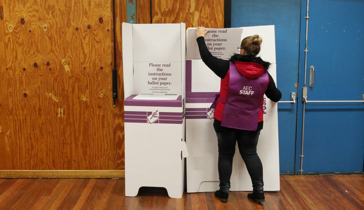 An AEC electoral workers sets up a polling booth for a federal election. Picture by Max Mason-Hubers 