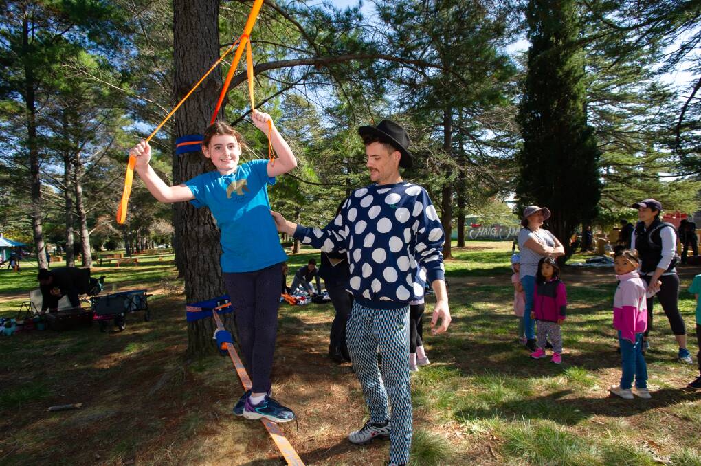 Mila O'Reilly, 9, of Chisholm with slackline instructor Scotty McKeown enjoying the Play Outside Day at Haig Park. Picture: Elesa Kurtz