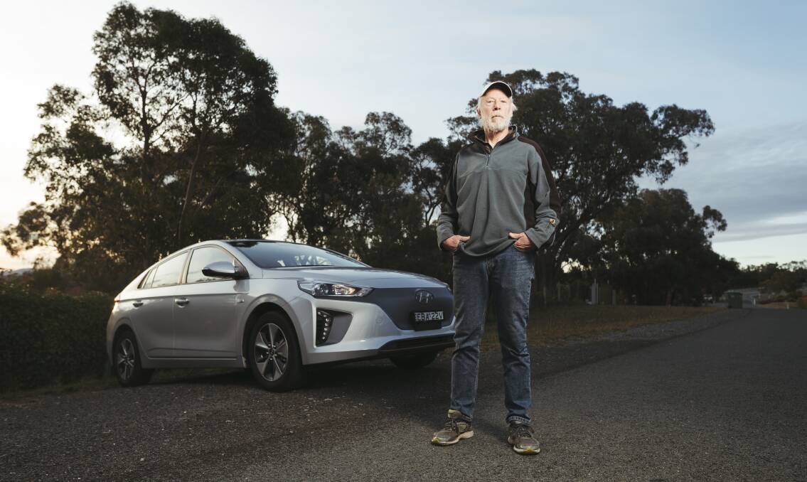 Former ANU astrophysics professor Frank Briggs, with his Hyundai IONIQ electric car, at his home in Queanbeyan. Picture: Dion Georgopoulos