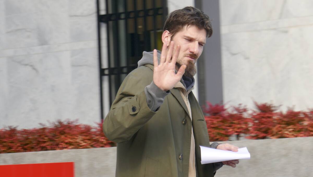 Cameron McKay, otherwise known as Cameron Robert of the McKay House, gesturing to journalists and said he would not make comments despite not being asked to. Picture: Toby Vue