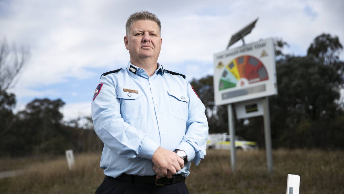 ACT RFS chief officer Rohan Scott at one of the damaged fire danger rating signs. Picture: Keegan Carroll