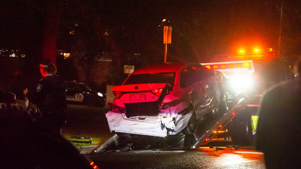 The smashed Camry is dragged onto the back of truck after it was forced off the road in Manuka. Picture: Elesa Kurtz