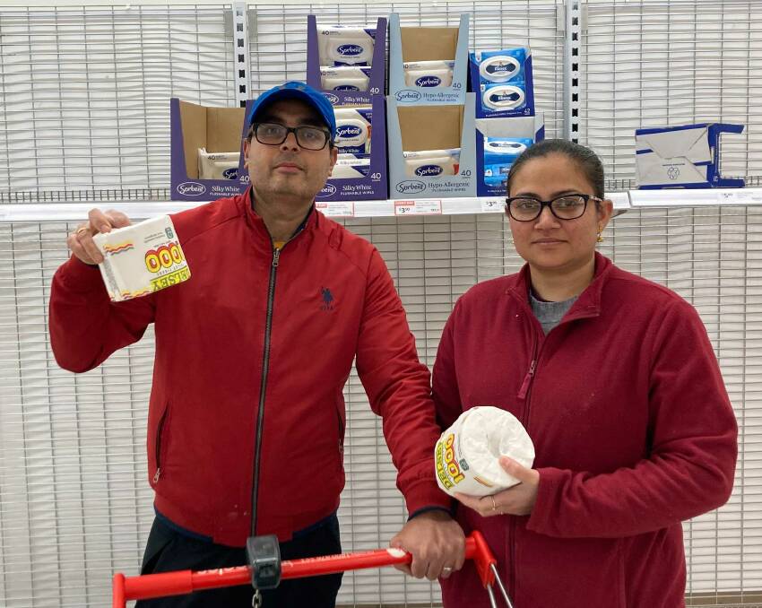 Vimal Kumer and Koran Simar with the last few rolls of toilet paper at Coles Jamison on Sunday night. Picture: Lanie Tindale