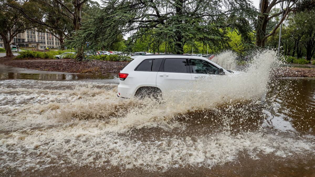 A vehicle navigates a flooded road in Parkes on Monday as rain continued to fall in Canberra for a second day. Picture by Sitthixay Ditthavong