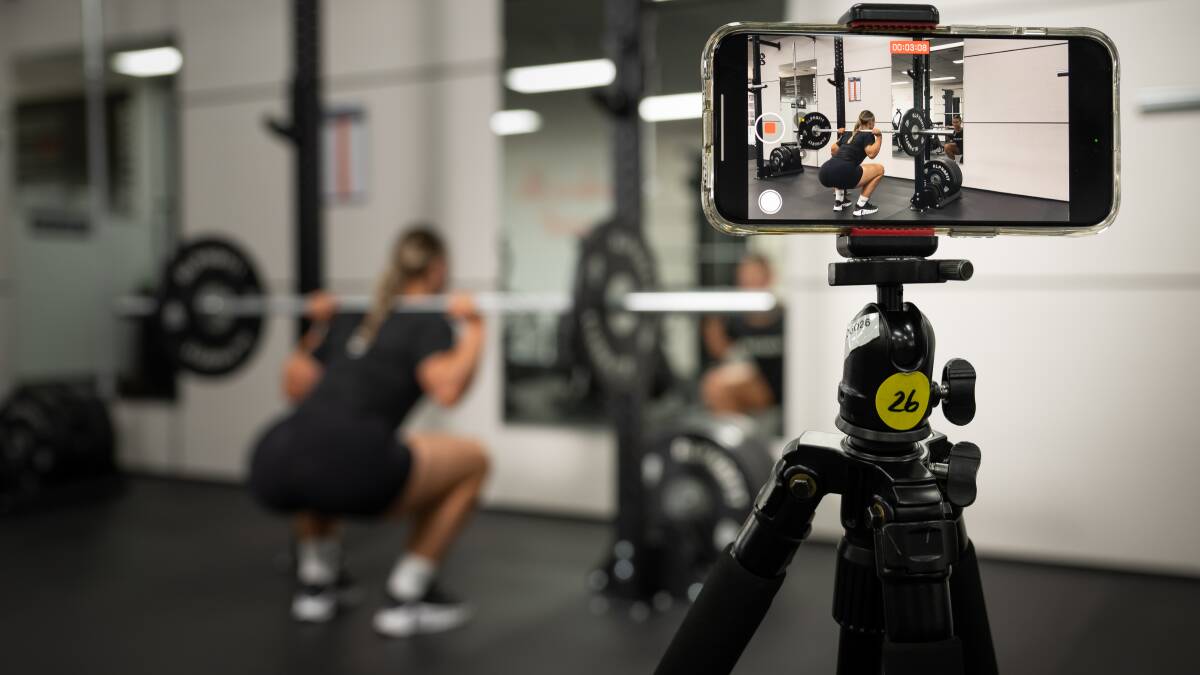 Online coach Emma Combs films herself in the gym. Picture by Elesa Kurtz
