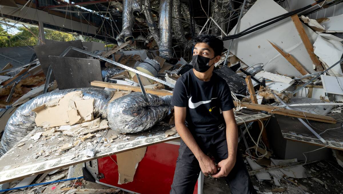 Fifteen-year-old Wasay Ashiq inside his family's damaged shop. Picture: Sitthixay Ditthavong 